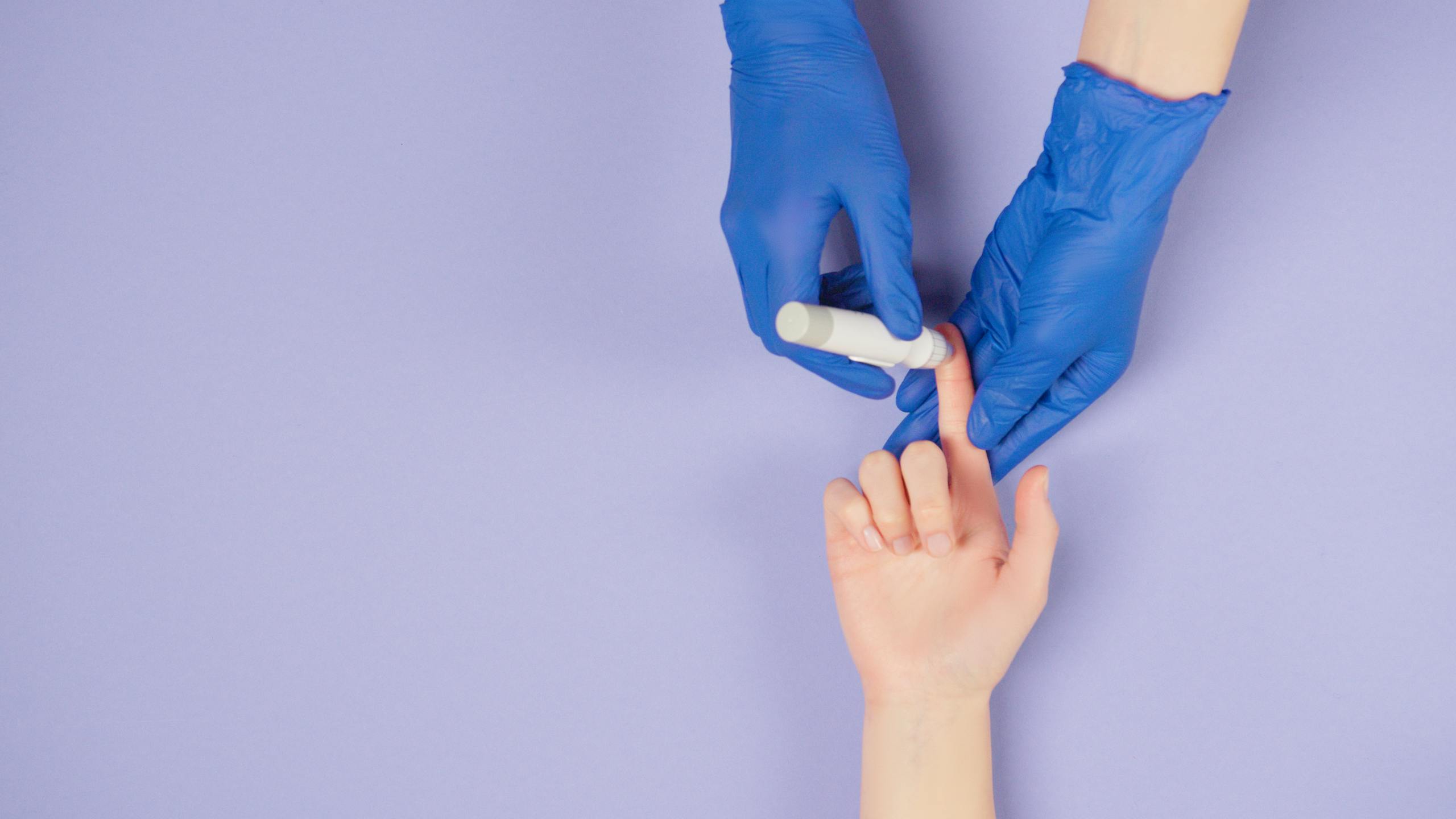 Medical professional using a glucose meter for a blood test against a pastel background.